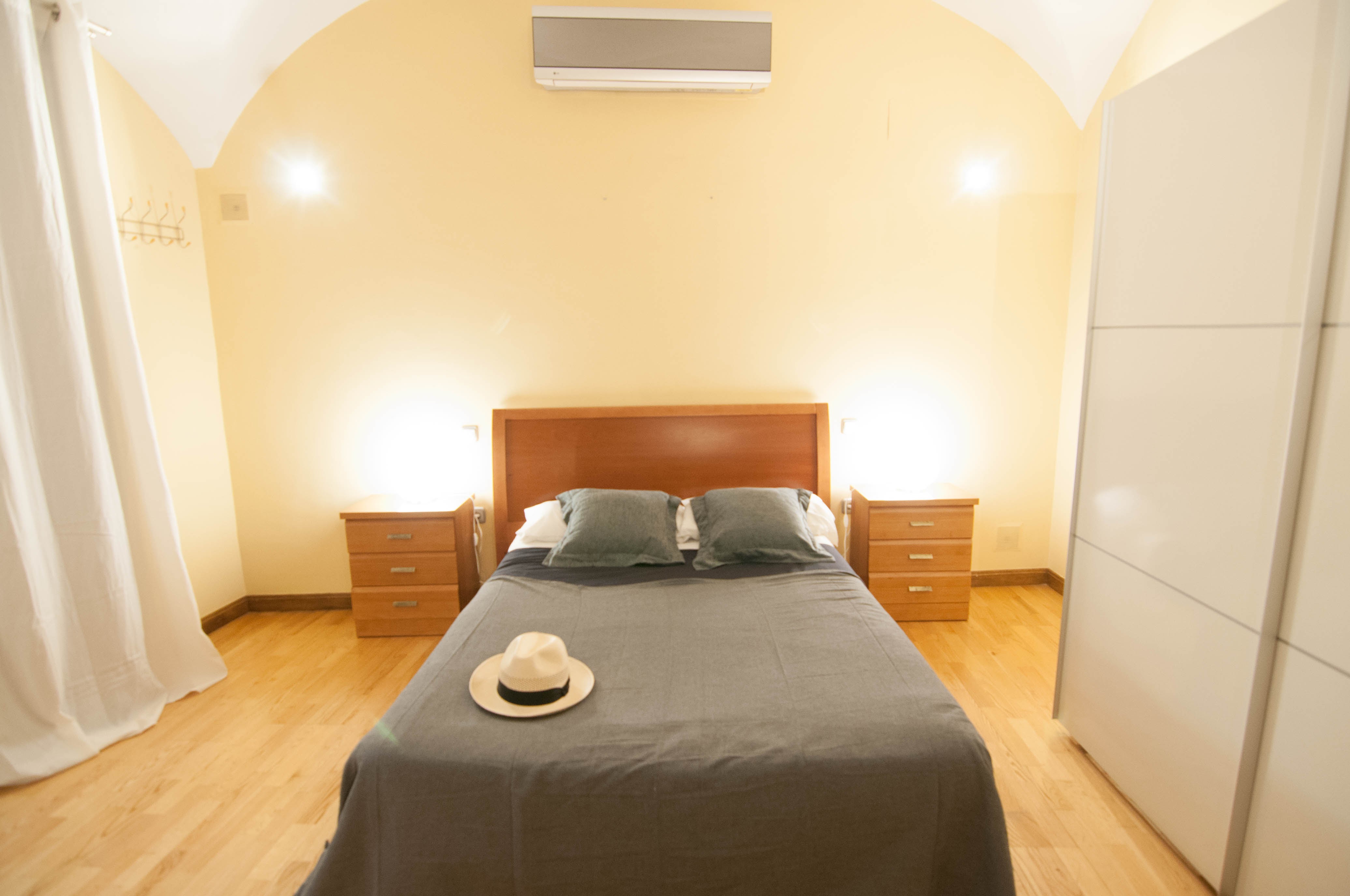 Cama principal de 150 en un ambiente diáfano y elegante.